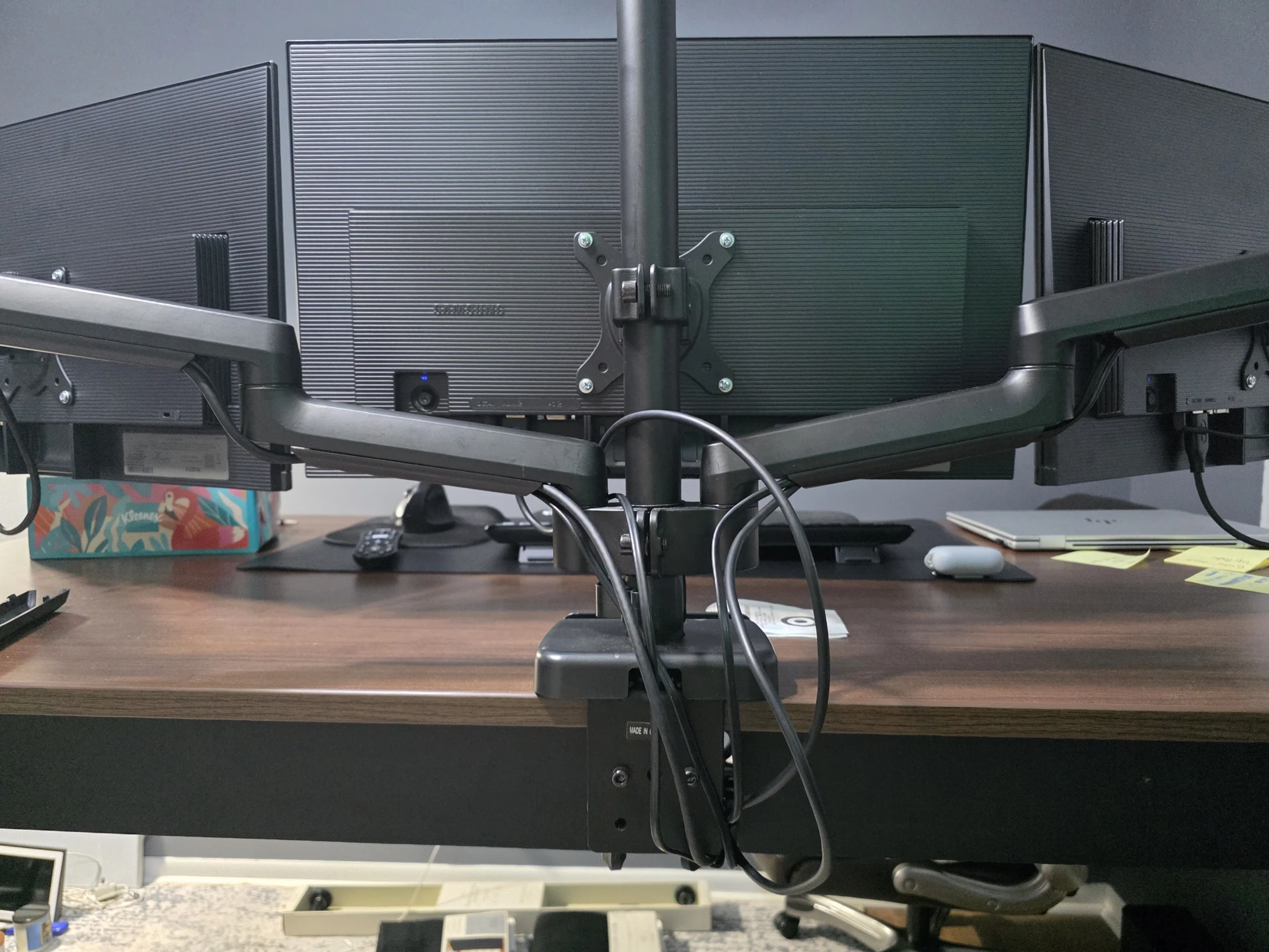 Rear view of a three-monitor desk after cable organization