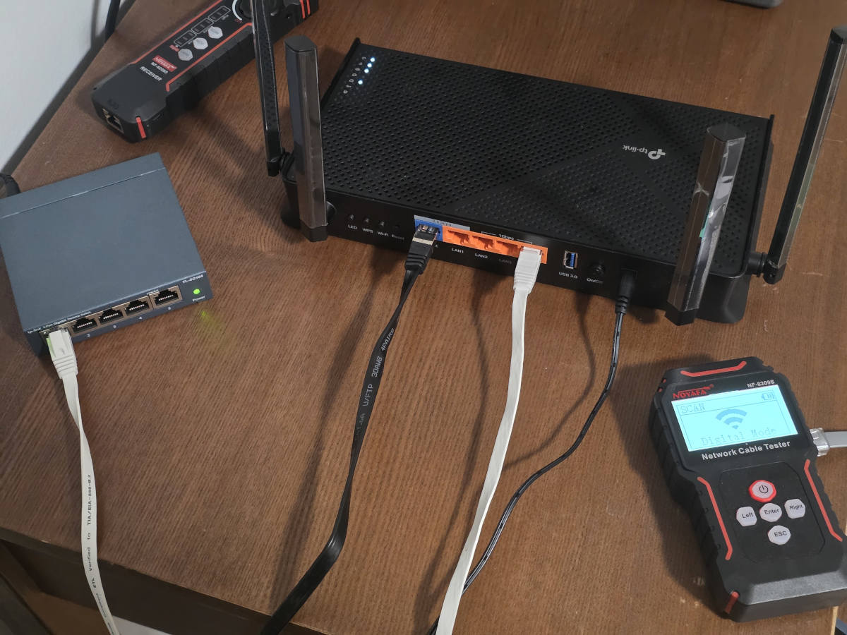 Router and Ethernet switch connected beside a network cable tester