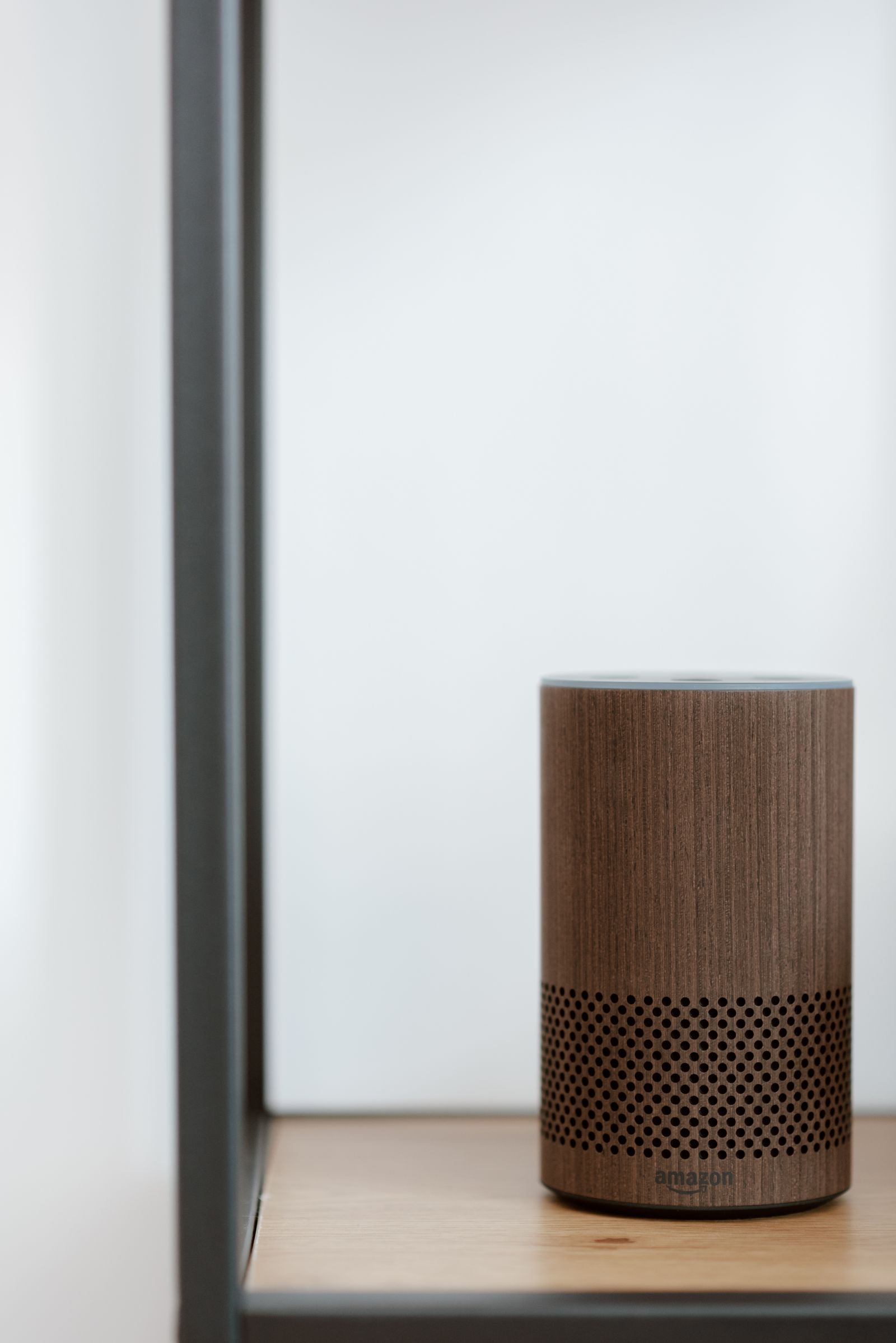 Stock reference of a wood-finish smart speaker on a shelf