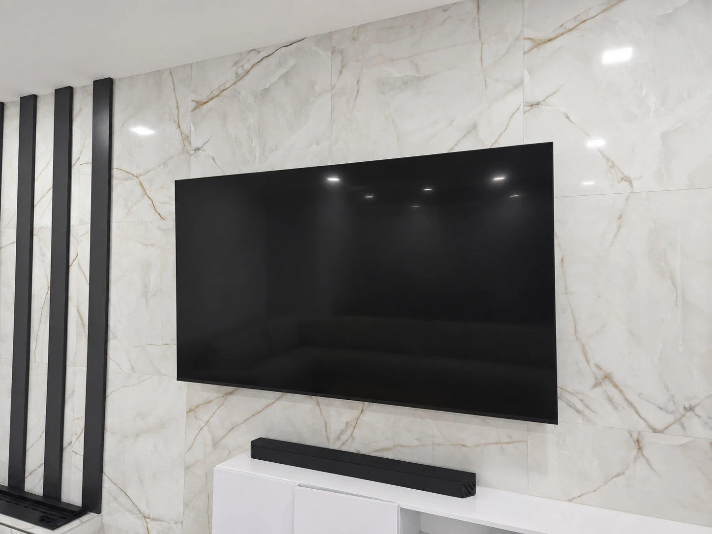 Large television mounted on a stone-look wall beside a fireplace