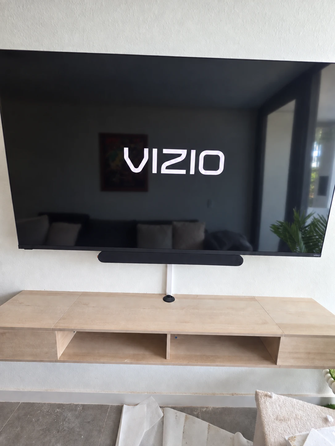 VIZIO television, soundbar and wall-mounted light wood console